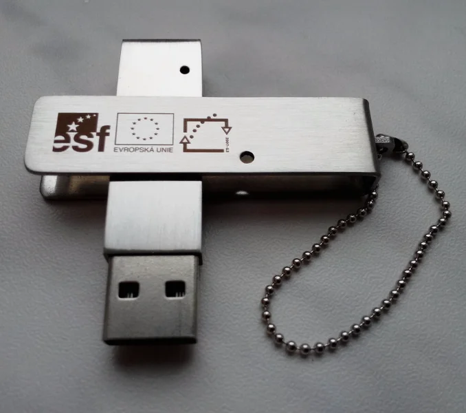 kovový otočný flash disk s gravírováním laserem - Otočný kovový flash disk s ukázkou tmavého loga ESF laserem.